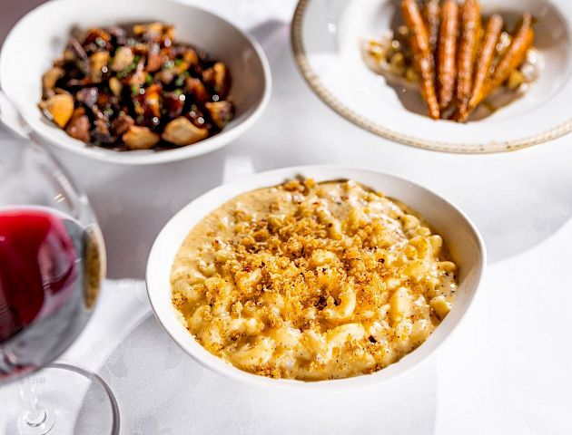 A variety of snacks: nuts, pretzels, popcorn, and French fries in bowls.